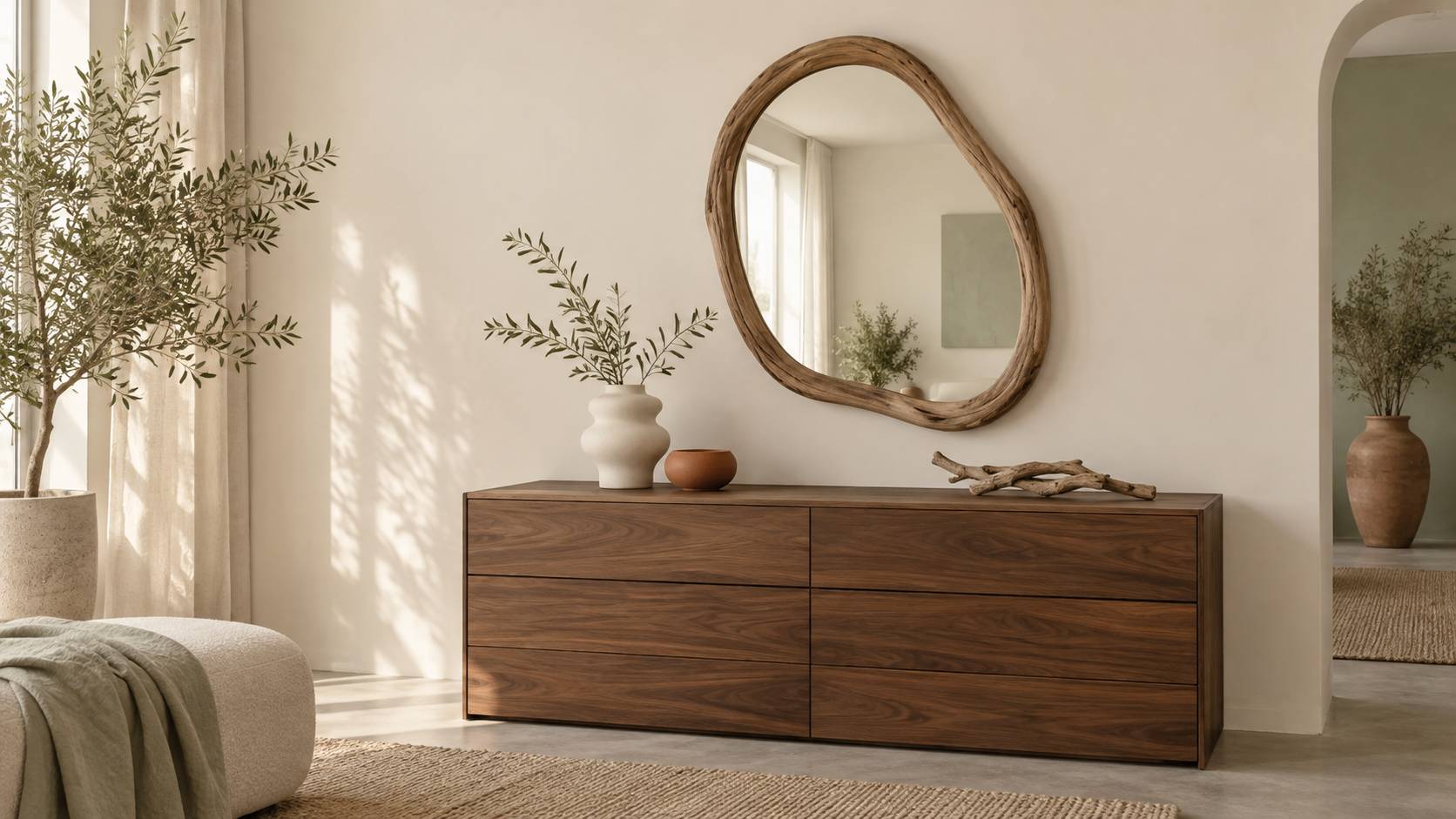 Miroir au cadre en bois flotté sur un mur clair avec branchages